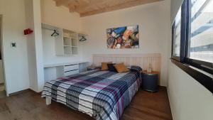 a bedroom with a bed and a painting on the wall at Cabañas Buena Vista - Santa Rosa in Santa Rosa de Calamuchita