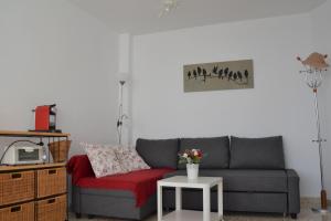 a living room with a gray couch and a red chair at Playa/piscina Apto Paraiso Rosa in Benajarafe