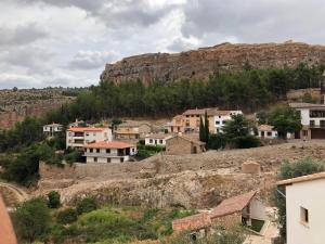 un villaggio su una collina con una montagna sullo sfondo di RUSTIKALPUENTE Casa del MEDICO a Alpuente