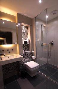 y baño con aseo, ducha y lavamanos. en The Continental Hotel, Heathrow, en Hounslow