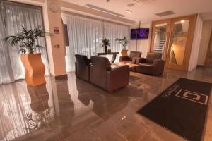 a living room with couches and a table at The Continental Hotel, Heathrow in Hounslow