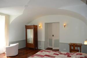 1 dormitorio con cama, espejo y ventana en l'Empereur - La Maïsou, en Sérignac