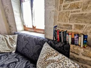 a couch in front of a brick wall with books at Aelia in Kamilari
