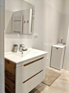 a white bathroom with a sink and a refrigerator at ClearVueHome - Quiet 51 m2 Studio Bratislava Slavin in Bratislava