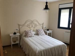 a bedroom with a bed with two tables and a window at Apartamentos Las Fuentes in Castropol