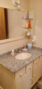 a bathroom counter with a sink and a mirror at Apartamento gramado RS centro in Gramado
