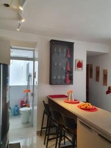 a kitchen with a bar with chairs and a counter top at Apto Praia das Toninhas in Ubatuba