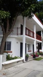 - un bâtiment blanc avec des balcons rouges et un arbre dans l'établissement Hospedaje Parras, à Parras de la Fuente