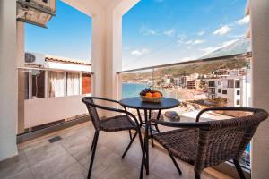 a balcony with a table and chairs and a view of the ocean at David Lux beach rooms in Dobra Voda
