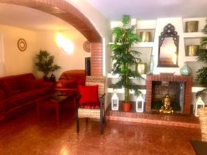 a living room with a fireplace and a red couch at GRAN CASA con TERRAZA a 3 min Playa con Wifi - rodeada de servicios in Roquetas de Mar