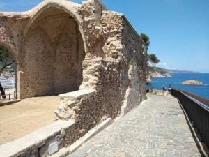 een oude stenen muur naast de oceaan bij Sant Jordi Santiago in Tossa de Mar