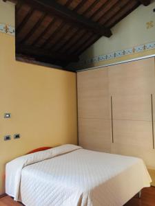 1 dormitorio con cama blanca y armarios de madera en apartments in the center of Ferrara excellent for Smart work, en Ferrara