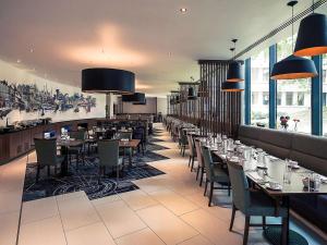 a restaurant with tables, chairs, and tables in it at Mercure Bristol Holland House in Bristol