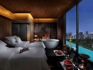 a hotel room with two beds and a bath tub at SO BANGKOK - SHA Extra Plus in Bangkok