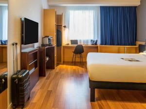 une chambre d'hôtel avec un lit et une télévision dans l'établissement ibis Genève Petit Lancy, à Genève