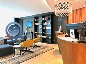 a office with a desk and chairs and a book shelf at Mercure Hotel Kaiserhof City Center in Frankfurt