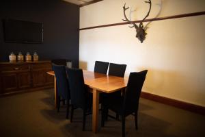a dining room with a wooden table and chairs at Makikihi Country Hotel in Waimate