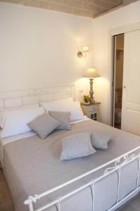 un grande letto bianco in una stanza con una lampada di Donna Lucrezia a Pezze di Greco