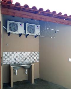 baño con lavabo y 2 aparatos de aire acondicionado en Maré Zen Gamboa en Morro de São Paulo