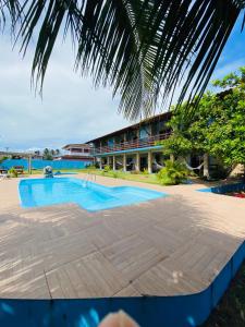 a swimming pool in front of a resort at Pousada Manga Azul in Barra de Camaratuba