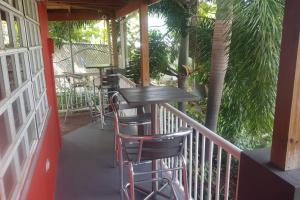 a balcony with a table and chairs on a porch at Always Summer Inn in Culebra