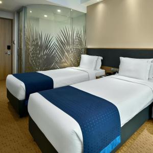 シンガポールにあるHoliday Inn Express Singapore Orchard Road, an IHG Hotelのベッド2台が隣同士に設置された部屋です。