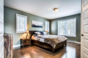 1 dormitorio con 1 cama y 2 ventanas en 3BDRM Zen Tremblant Chalet - Ski/Hike/Swim en Lac-Superieur