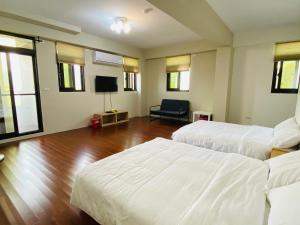 a hotel room with two beds and a television at Home of 120 B&B in Jiaoxi
