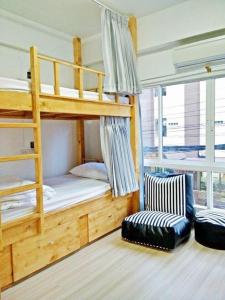a bedroom with two bunk beds and a chair at The Chiang Mai Walkers in Chiang Mai