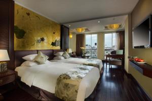 a hotel room with two beds and a television at Golden Silk Boutique Hotel in Hanoi