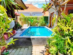 una piscina en un patio con plantas en G Saskara Homestay, en Sanur