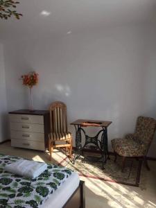 a bedroom with a bed and a desk and chairs at Noclegi Dobry Kwadrat in Bodzentyn