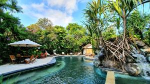 een zwembad in een resort met een waterval bij Puri Cendana Resort Bali in Seminyak