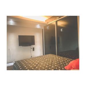 een slaapkamer met een bed en een flatscreen-tv bij The ceo suites by Zenbnb in Bayan Lepas