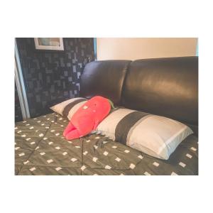 uma almofada vermelha sentada numa cama com almofadas em The ceo suites by Zenbnb em Bayan Lepas