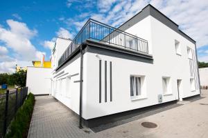 Cette maison blanche dispose d'un balcon sur le côté. dans l'établissement Hostel SMS, à Bydgoszcz