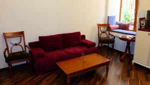 a living room with a red couch and two chairs at Затишні апартаменти, вулиця Дерибасівська, 13 in Odesa