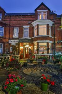 a house with chairs and flowers in front of it at The Kensington in Scarborough