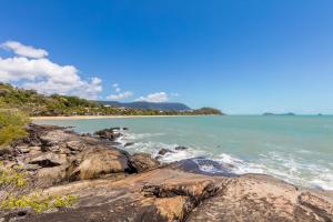 a view of a beach with rocks and the ocean at Mediterranean Beachfront Apartments in Yorkeys Knob