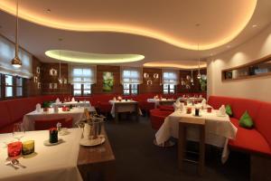 a restaurant with tables and red booths at Hotel-Restaurant Adler in Lahr