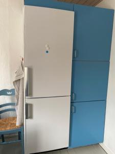 a white refrigerator with a blue door in a room at Bed & coffee Hjørring in Hjørring