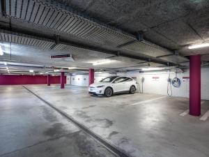 ein weißes Auto parkt auf einem Parkplatz in der Unterkunft OfficeWerft Business-Apartments in Luzern