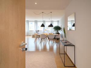 a dining room and living room with a table and chairs at OfficeWerft Business-Apartments in Lucerne