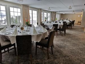 uma sala de banquetes com mesas, cadeiras e janelas em Sanner Hotell em Gran