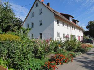 un edificio blanco con flores delante en Ferienwohnung am Radweg en Ruprechtsbruck