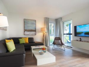 ein Wohnzimmer mit einem Sofa und einem TV in der Unterkunft Terrassenwohnung "Treibholz" - Oase am Haff in Garz