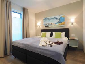 1 dormitorio con 1 cama grande con almohadas verdes en Terrassenwohnung "Treibholz" - Oase am Haff, en Garz