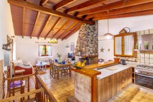 a kitchen and dining room with wooden ceilings at Can Sito in Cala Tuent