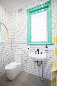 a bathroom with a toilet and a sink and a window at Coogee Beach House in Sydney