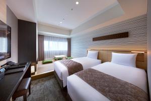 東京にある住友不動産 ホテル ヴィラフォンテーヌ グランド 東京有明のベッド2台とテレビが備わるホテルルームです。